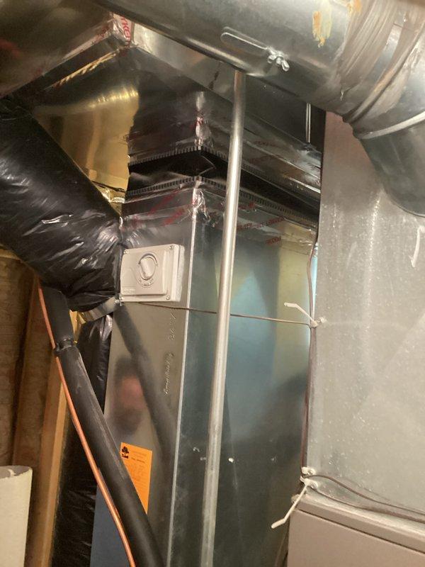 Conducted comprehensive assessment of existing HVAC system for complete replacement estimate. Documented current installation including gray furnace unit with mounted humidifier, air handler, evaporator coil assembly, and associated ductwork in basement utility area. Evaluated all system components, PVC venting and drainage lines, copper refrigerant lines with insulation, flexible ductwork connections, and control wiring. Photographed equipment specifications, piping configurations, and spatial constraints to provide accurate replacement recommendations and ensure proper sizing for new system installation.