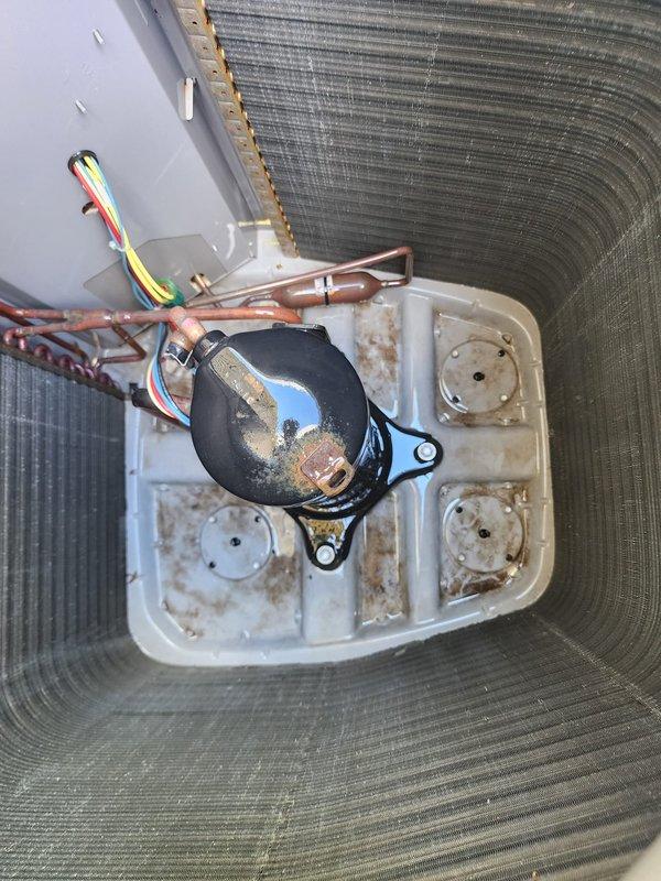 Completed annual maintenance on residential air conditioning system under WFS plan as non-covered visit. Performed comprehensive inspection of outdoor condensing unit including visual assessment of compressor, refrigerant lines, and electrical connections. Noted moderate aging and weathering on compressor with surface oxidation present on casing and drain pan showing rust staining from moisture exposure. Verified condenser coil condition and protective mesh panels intact. Confirmed unit operational status and proper mounting on concrete pad with electrical disconnect accessible.