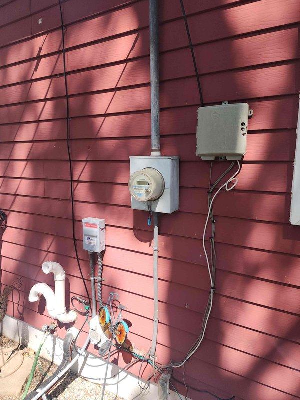 Completed residential electrical panel upgrade including installation of new 200-amp main breaker panel with dual rows of circuit breakers, generator interlock system with Detroit Edison-approved disconnect switch, and updated circuit directory documentation. Relocated and upgraded exterior electrical service equipment including new meter base installation, electrical conduit routing, and proper grounding connections to meet current code requirements.