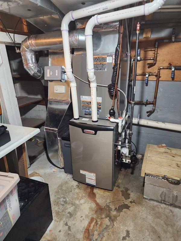 Completed full HVAC system installation including Lennox heat pump, gas furnace, air conditioning unit, and two S40 smart thermostats. Installed furnace in basement utility area with proper venting through white PVC intake and exhaust pipes, connected refrigerant lines with isolation valves, and integrated metallic supply ductwork. Mounted air handler unit horizontally in attic space across floor joists with black flexible ductwork connections and condensate drainage piping. Installed copper refrigerant line sets connecting outdoor heat pump unit to indoor components. Mounted and programmed both S40 thermostats for zone control. Verified all electrical connections at furnace control board and air handler, confirmed proper voltage and amperage readings. Tested system operation in heating and cooling modes, checked refrigerant pressures and superheat/subcooling values within manufacturer specifications. Confirmed adequate airflow across evaporator coil and heat exchanger. Verified conden