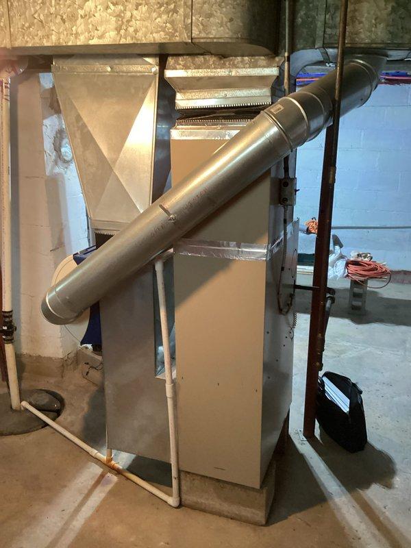 Completed comprehensive estimate for whole-house HVAC system replacement including 25-year-old furnace located in basement and 25-year-old air conditioning unit positioned outside near back door. Both units currently operational but have reached end of expected service life. Documented existing equipment configuration, ductwork connections, and installation conditions with photographic evidence for replacement planning.