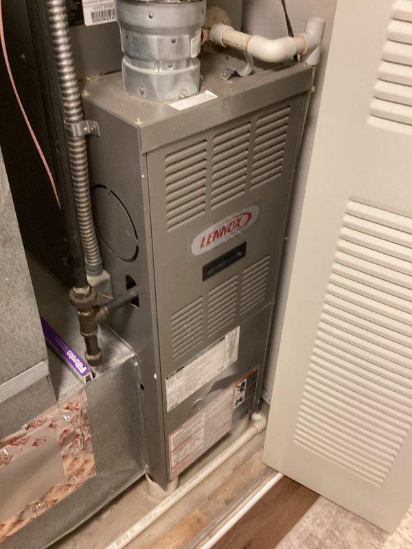 Conducted on-site evaluation for complete HVAC system replacement including 20-year-old Lennox furnace located in interior closet and matching-age outdoor condensing unit. Documented existing equipment configuration, ductwork connections, electrical panel setup with dual breaker arrangement, and PVC condensate drainage system. Noted moisture staining on concrete pad beneath furnace and photographed current installation layout to facilitate accurate replacement equipment sizing and installation planning.