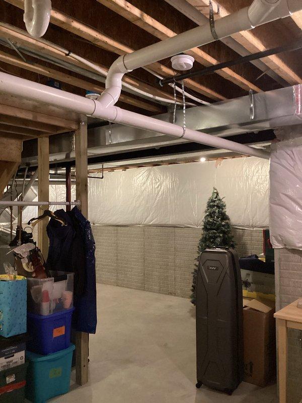Provided estimate for replacement of 12-year-old air conditioning system currently located at exterior of home with condenser positioned on ground-level pad adjacent to building. Existing unit operational but evaluated for replacement due to age and efficiency considerations. Assessment included review of outdoor condenser unit with electrical disconnect, refrigerant lines, and basement-level air handler or evaporator coil connected to existing ductwork system.