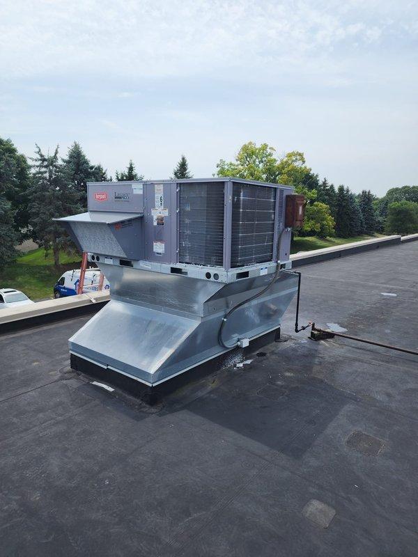 Completed installation of Bryant 5-ton, 110,000 BTU packaged rooftop unit on commercial building. Unit was crane-lifted into position at scheduled time and mounted on existing galvanized metal roof curb with proper sealing and weatherproofing. All electrical connections, refrigerant lines, and ductwork transitions were completed per manufacturer specifications, and system was tested for proper operation before final commissioning.