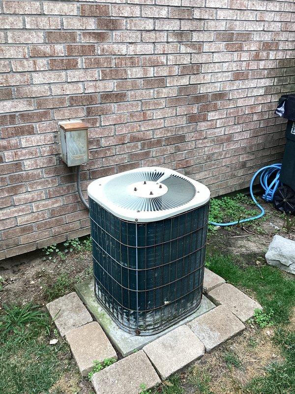 Conducted comprehensive on-site evaluation for complete HVAC system replacement and hot water tank installation. Assessed existing outdoor air conditioning condenser unit positioned on concrete pad against exterior brick wall, noting current operational status and physical condition. Evaluated interior furnace system with existing ductwork configuration and electrical panel setup in basement utility area. Documented equipment specifications, spatial requirements, and infrastructure compatibility for full system replacement proposal. Photographed current equipment installations to support estimate preparation for homeowner's consideration of heating, air conditioning, and hot water tank replacement options.