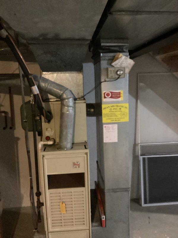 Conducted comprehensive on-site evaluation for complete HVAC system replacement and hot water tank installation. Assessed existing outdoor air conditioning condenser unit positioned on concrete pad against exterior brick wall, noting current operational status and physical condition. Evaluated interior furnace system with existing ductwork configuration and electrical panel setup in basement utility area. Documented equipment specifications, spatial requirements, and infrastructure compatibility for full system replacement proposal. Photographed current equipment installations to support estimate preparation for homeowner's consideration of heating, air conditioning, and hot water tank replacement options.