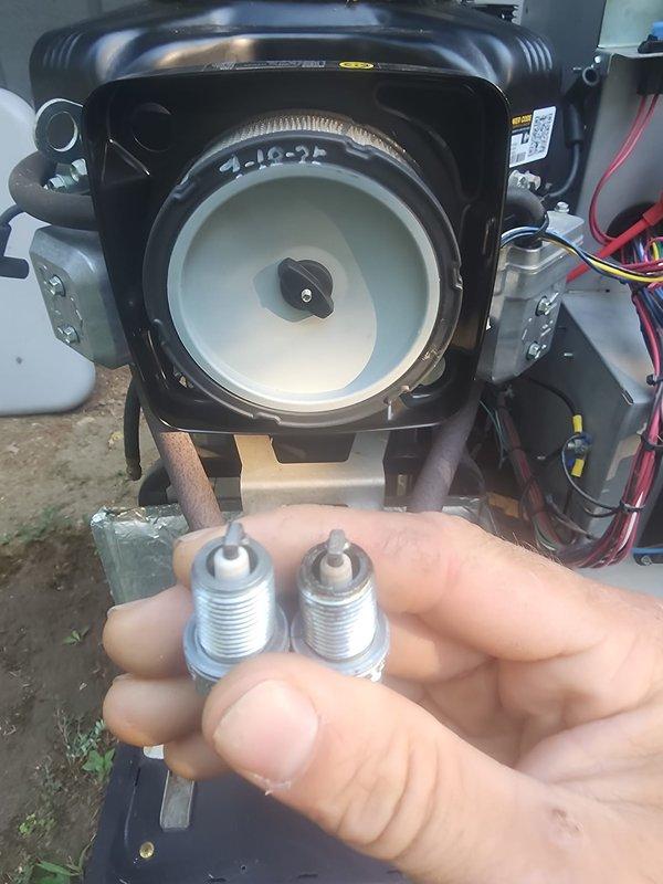 Performed scheduled maintenance on Vanguard 627cc generator unit. Removed and replaced both spark plugs, inspected engine cooling system and fan assembly, and verified electrical connections and wiring harnesses. Observed weathering and oxidation on mounting brackets and external components consistent with outdoor installation. Battery connections checked and found secure. Unit tested and returned to service.
