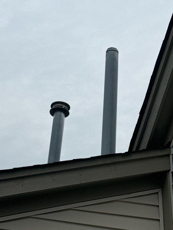 Conducted site inspection of residential chimney venting system and identified deteriorated metal B-vent cap requiring replacement. Documented existing 4-inch diameter galvanized vent pipe configuration with weathered cap showing signs of age and exposure. Provided estimate for replacement of chimney cap with new 4-inch metal B-vent cap to restore proper venting function and prevent weather intrusion.