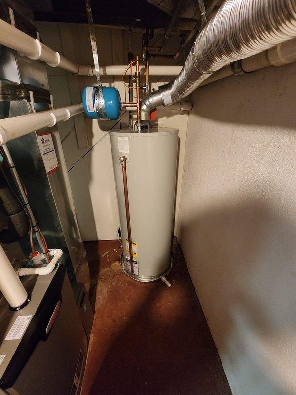 Successfully installed a new 50-gallon tanked water heater in the residential utility room. The installation included proper connection of copper supply and discharge piping, integration with the existing blue expansion tank mounted on the wall, and verification of all plumbing connections for leak-free operation. All work was completed to code specifications, and the unit was tested and confirmed operational upon completion.