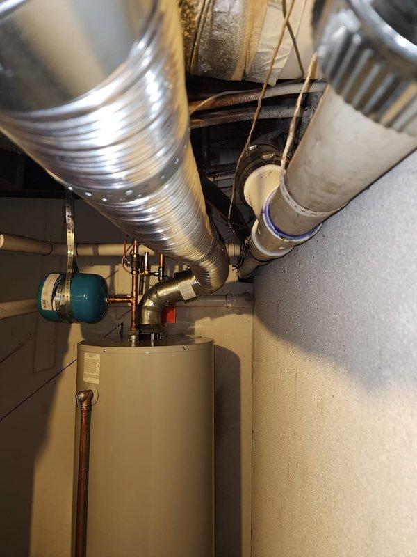 Successfully installed a new 50-gallon tanked water heater in the residential utility room. The installation included proper connection of copper supply and discharge piping, integration with the existing blue expansion tank mounted on the wall, and verification of all plumbing connections for leak-free operation. All work was completed to code specifications, and the unit was tested and confirmed operational upon completion.