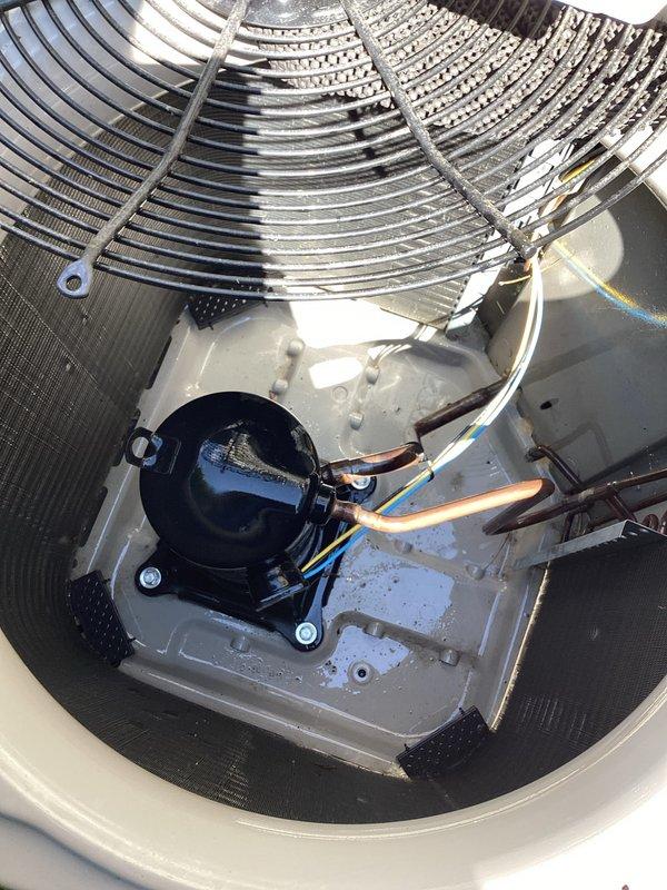 Responded to service call for intermittent buzzing noise and inadequate cooling from air conditioning system. Upon arrival, performed visual inspection of outdoor condenser unit, examining protective grille, condenser coil fins, fan assembly, compressor, refrigerant lines, and electrical connections. Documented equipment condition with photographs showing normal wear consistent with outdoor exposure and minor accumulation of dirt and debris on internal components and base plate.