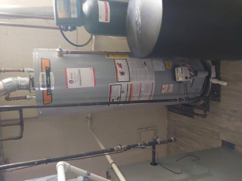 Completed warranty work to bring water heater installation into compliance with 2021 Michigan Plumbing Code Chapter 5, Section 504.7 through 504.7.2. Installed drain pan beneath existing water heater unit in basement mechanical room to meet code requirements for overflow protection. Verified proper installation of HVAC system components including furnace unit mounted on metal platform, expansion tank, ductwork connections, and associated piping systems all functioning correctly following pan installation.