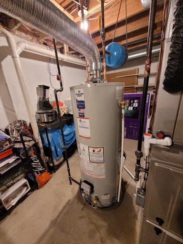 Successfully installed a new 50-gallon tanked water heater in the basement utility room. Positioned the unit on the concrete floor and completed all necessary water supply connections using copper piping. Installed and properly suspended a blue expansion tank from the ceiling joists to protect the system from thermal expansion. Connected all hot and cold water lines with appropriate shutoff valves and applied foam insulation to designated piping sections. Ensured proper venting configuration and verified all connections for leaks. System was tested, filled, and confirmed operational with no issues detected.