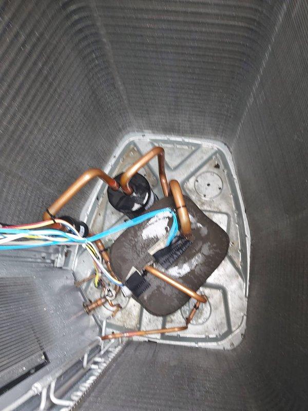 Responded to service call for condensation in basement with ice buildup on air conditioning unit. Upon arrival, confirmed evaporator coil had experienced freezing condition. Advised customer to allow unit to completely thaw before system restart. Utilized Fieldpiece SMAN refrigerant manifold with micron gauge to assess system pressures and performance. Measured refrigerant pressures showing LOW side reading of 124.9 PSI and HIGH side reading of 208.7 PSI for R410A refrigerant system. Inspected evaporator coil assembly and copper refrigerant lines within ductwork, checking for proper connections and electrical wiring integrity. Documented system conditions with photographic evidence showing gauge readings and internal coil access panel. Confirmed multi-colored control wiring and copper tubing configuration were properly secured with cable management. Scheduled follow-up assessment after thaw period to determine root cause of freezing condition, which may include restricted airflow, low 