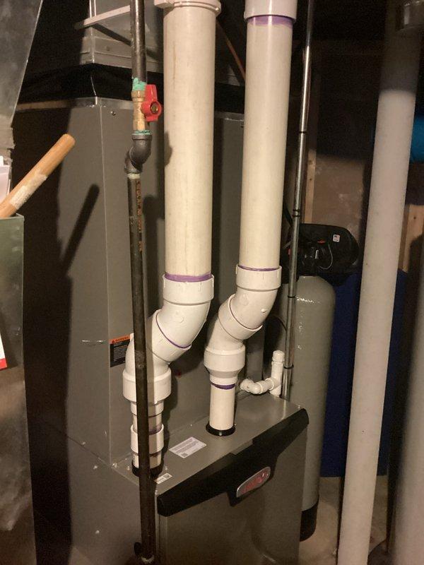 Completed HVAC estimate for air conditioning system replacement at residential property. Documented existing equipment configuration in basement mechanical room, including furnace unit, PVC condensate drainage system, and associated plumbing components. Photographed current installation to assess replacement requirements and provide customer with comprehensive proposal for new AC system installation.
