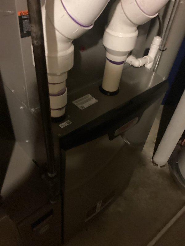 Completed HVAC estimate for air conditioning system replacement at residential property. Documented existing equipment configuration in basement mechanical room, including furnace unit, PVC condensate drainage system, and associated plumbing components. Photographed current installation to assess replacement requirements and provide customer with comprehensive proposal for new AC system installation.