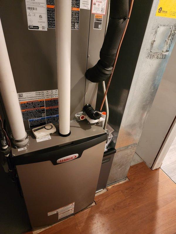 Completed full HVAC system installation including Lennox furnace, air conditioning condensing unit, and S40 smart thermostat. The furnace was positioned in the basement utility area with proper ductwork connections, refrigerant line routing, and PVC condensate drainage system. The outdoor condensing unit was installed on a brick platform with refrigerant lines properly insulated and connected, electrical junction box mounted, and condensate drain piping configured. All components were tested, charged, and verified operational upon completion.