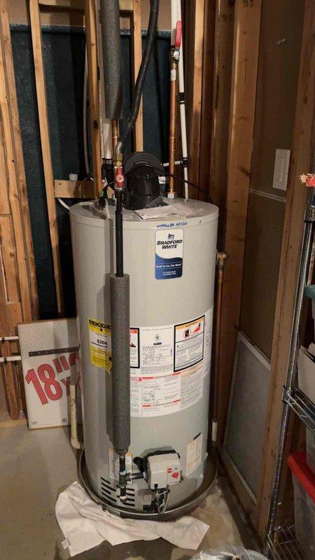 Responded to no cooling call for residential HVAC system over 10 years old. Upon arrival, discovered service call documentation referenced water heater installation rather than air conditioning equipment, as evidenced by photos showing Bradford White water heater unit with expansion tank, copper piping, and red-handled valves in unfinished basement area. Unable to complete AC diagnostic or repairs as no cooling equipment was accessible or photographed during this service visit.