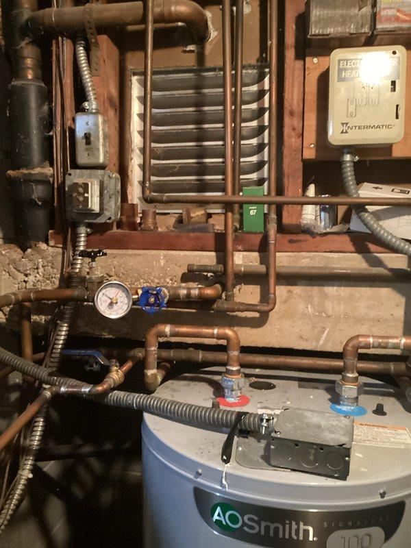 Conducted comprehensive boiler system evaluation for 30-year-old unit experiencing active leaks. Documented existing mechanical room configuration including interconnected heating and plumbing infrastructure, assessed copper piping network showing age-related deterioration, and photographed current equipment conditions to support replacement recommendations due to system age and compromised integrity.