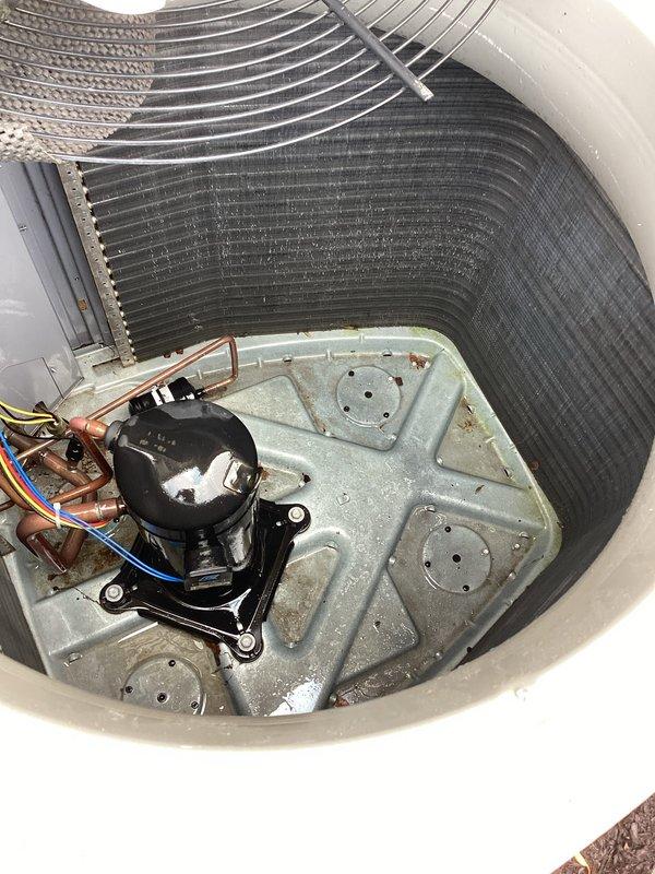 Responded to service call for water leaking from under furnace. Upon inspection, identified condensate drainage issue and addressed the problem. Documented equipment condition with photos showing interior components of outdoor condensing unit, including compressor, evaporator coils with visible dust accumulation, and base plate with some corrosion present. Customer advised to schedule air conditioning maintenance service for comprehensive system evaluation and cleaning.