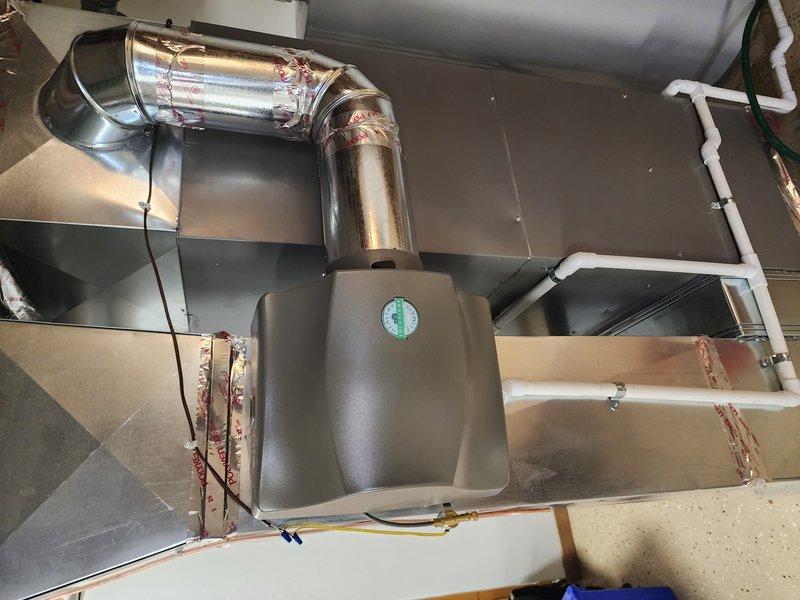 Completed full HVAC system installation including Lennox furnace, air conditioning unit, and S40 smart thermostat. The indoor air handler was positioned in the mechanical room with new supply and return ductwork connections, refrigerant line sets, condensate drainage, and electrical wiring properly installed and secured. The outdoor condensing unit was set on a concrete pad against the exterior brick wall with appropriate clearances, connected to power supply, and refrigerant lines run through the wall penetration. All components were tested for proper operation, system charged to manufacturer specifications, and thermostat programmed and synced with equipment.