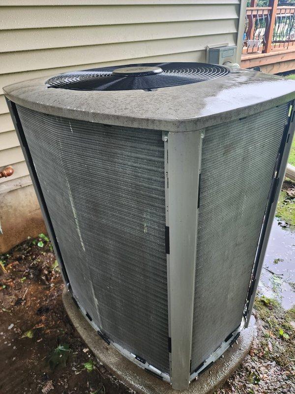 Completed annual cooling system maintenance on residential air conditioning unit. Performed comprehensive inspection of outdoor condenser unit, including evaluation of heat exchanger coils which showed environmental weathering and dirt accumulation, and assessed internal components revealing corrosion on mounting bracket and proper refrigerant line connections. System operational and ready for cooling season.