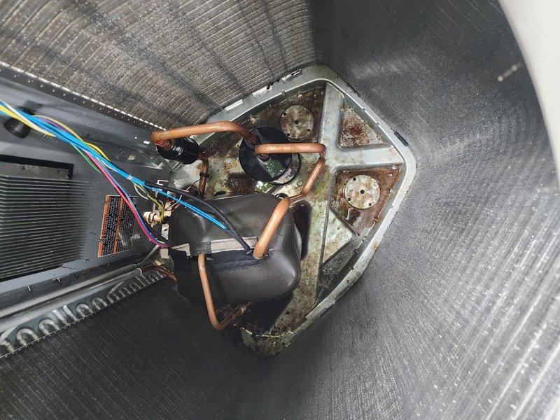 Completed annual cooling system maintenance on residential air conditioning unit. Performed comprehensive inspection of outdoor condenser unit, including evaluation of heat exchanger coils which showed environmental weathering and dirt accumulation, and assessed internal components revealing corrosion on mounting bracket and proper refrigerant line connections. System operational and ready for cooling season.