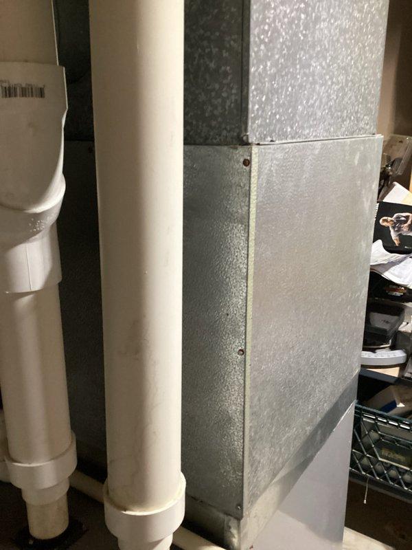 Completed comprehensive HVAC system replacement estimate for residential property. Assessed existing outdoor condensing unit location near electrical meter on exterior brick wall, noting vegetation clearance requirements for proper airflow and service access. Evaluated indoor air handler installation in utility area with existing ductwork and drainage systems, documenting current equipment configuration and spatial considerations for replacement unit sizing and positioning.
