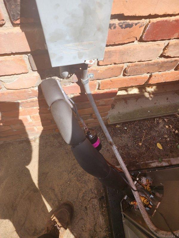 Completed installation of new Lennox air conditioning system at residential property. Replaced existing outdoor condenser unit with new Bryant model, positioning unit on composite pad against brick exterior wall beneath window. Connected refrigerant lines with brass fittings and completed electrical hookup with disconnect box mounted to wall via conduit. Replaced supply canvas ductwork and reinstalled UV light into new supply metal plenum. Installed new condensate pump with corrugated drain tubing routed to sump pump system for proper drainage. Verified all electrical connections, tested system operation, and confirmed proper airflow and cooling performance.