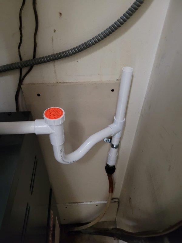 Completed warranty follow-up for A/C replacement addressing final mechanical inspection violations. Reinstalled condensate drain system using rigid PVC piping from air handler cabinet to existing flex drain connection, including proper P-trap installation and cleanout access fitting per code requirements. Repositioned refrigerant line set to maintain required 6-inch clearance from single-wall furnace exhaust pipe to combustible materials. Secured A/C suction line with proper support clamps to eliminate movement and ensure system integrity. Documented all corrections with photographs and provided equipment manual to homeowner.