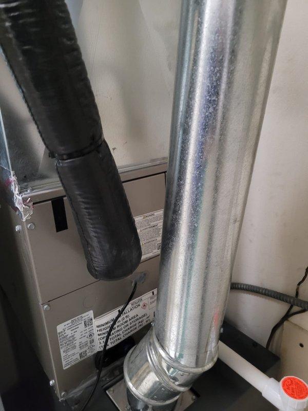 Completed warranty follow-up for A/C replacement addressing final mechanical inspection violations. Reinstalled condensate drain system using rigid PVC piping from air handler cabinet to existing flex drain connection, including proper P-trap installation and cleanout access fitting per code requirements. Repositioned refrigerant line set to maintain required 6-inch clearance from single-wall furnace exhaust pipe to combustible materials. Secured A/C suction line with proper support clamps to eliminate movement and ensure system integrity. Documented all corrections with photographs and provided equipment manual to homeowner.