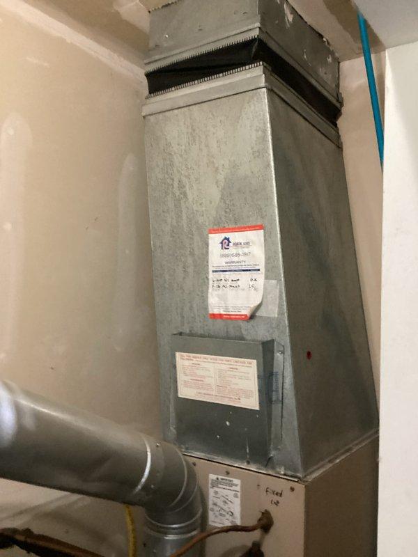 Completed estimate for 10-12 SEER air conditioning system replacement in utility room. Assessed existing ductwork configuration including galvanized metal T-junction connections and evaluated installation space adjacent to water heater with gas line. Documented current HVAC unit with filter access and rigid metal ductwork connections for replacement specifications.