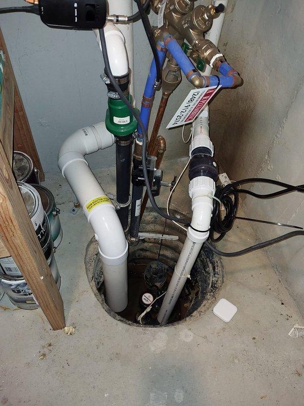 Responded to service call for leaking humidifier drain pipe connected to basement furnace. Upon inspection, confirmed active leak at drain line connection point on 13-year-old humidifier unit mounted to Bryant furnace system. Documented existing plumbing configuration including condensate pump assembly, PVC drain lines, and associated connections. Assessed humidifier age and condition, noting unit has reached expected service life. Verified HVAC system continues to operate normally for heating and cooling functions despite humidifier drain issue. Photographed installation setup showing drain pipe routing, condensate pump location, and humidifier mounting arrangement for reference. Recommended drain pipe replacement to resolve leak and prevent water damage to basement area.