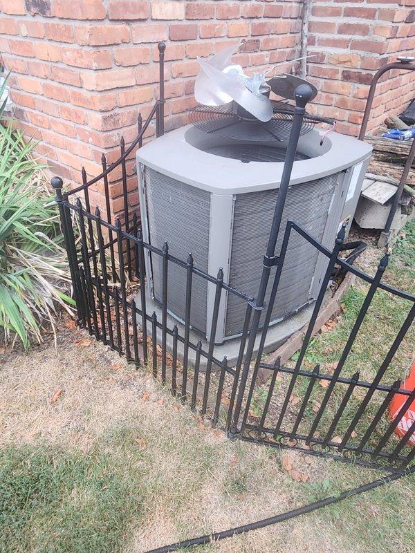 Completed scheduled air conditioning maintenance on residential split system. Connected refrigerant manifold gauges and recorded operating pressures and temperatures. High side pressure reading 249.4 PSIG, low side pressure 83.3 PSIG with 9.3°F subcooling observed during system operation. Inspected outdoor condenser unit located in fenced enclosure against building exterior. Unit operating within normal parameters with no immediate service concerns identified.