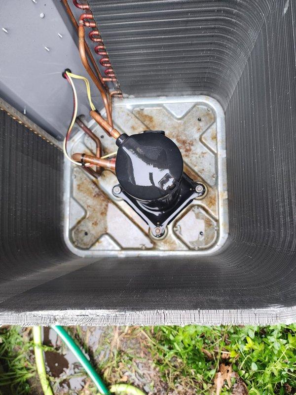 Completed scheduled maintenance tune-up on outdoor air conditioning unit as part of prepaid maintenance program. Accessed internal components by removing exterior housing panels and performed comprehensive inspection of heat exchanger coils, refrigerant lines, compressor assembly, and electrical connections. Noted age-related wear including rust staining on condensate pan and debris accumulation within cabinet, though system remains fully operational with no performance issues reported. All components functioning within normal parameters.