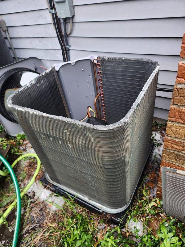 Completed scheduled maintenance tune-up on outdoor air conditioning unit as part of prepaid maintenance program. Accessed internal components by removing exterior housing panels and performed comprehensive inspection of heat exchanger coils, refrigerant lines, compressor assembly, and electrical connections. Noted age-related wear including rust staining on condensate pan and debris accumulation within cabinet, though system remains fully operational with no performance issues reported. All components functioning within normal parameters.