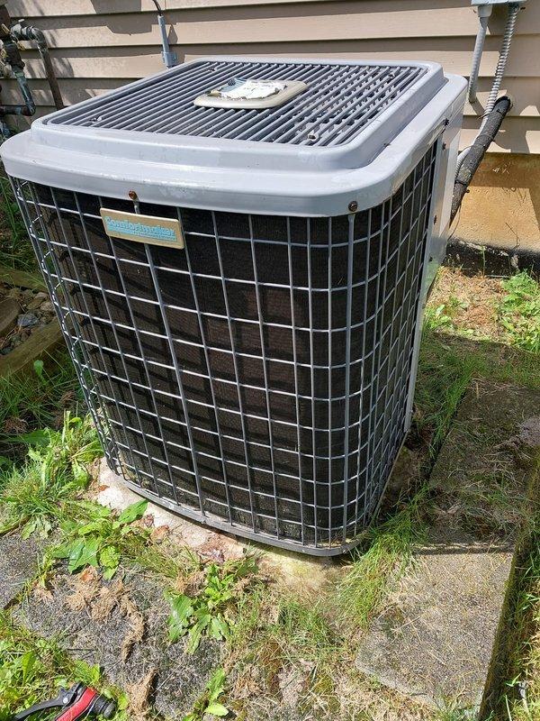 Completed scheduled cooling system maintenance on residential air conditioning unit. Performed comprehensive inspection of outdoor condenser unit, which showed normal operational wear with minor vegetation growth around concrete pad perimeter. Inspected condensate drain pan assembly, noting significant rust and corrosion buildup along edges and seams indicating extended service exposure to moisture. System operational and maintaining proper cooling function at time of service completion.