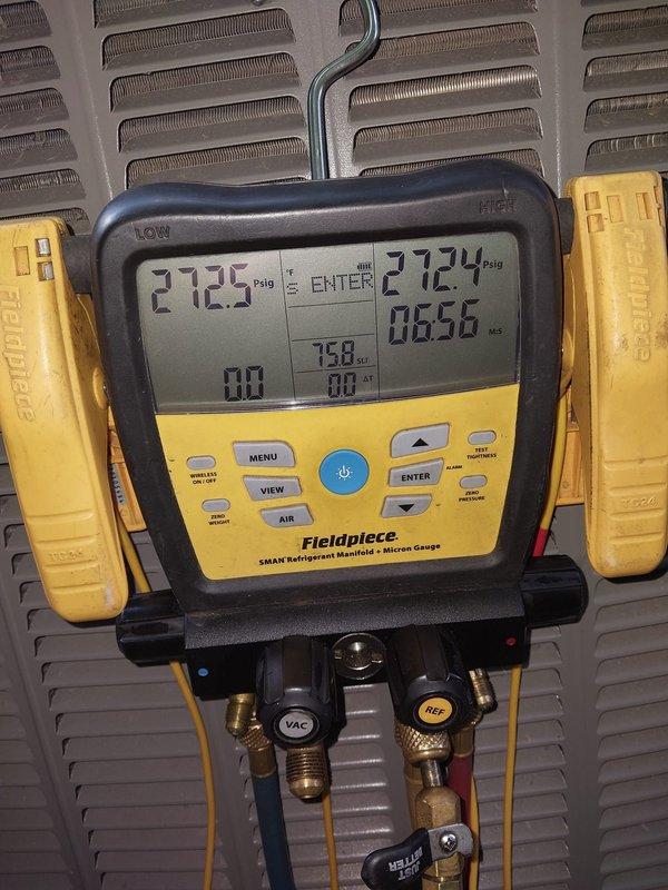 Responded to callback for recently installed AC system blowing warm air and not cooling properly. Upon arrival, performed comprehensive diagnostics using refrigerant manifold gauges and micron gauge to assess system pressures and vacuum levels. Measurements indicated abnormal pressure readings of 2725 and 2724 psig, suggesting potential refrigerant charge issues or system restrictions. Conducted vacuum testing which revealed readings of 563 microns with a decay rate of 2.2 microns per minute, indicating possible leak in the refrigeration circuit. Accessed crawlspace area to inspect indoor unit components and ductwork connections. Identified and documented system conditions with diagnostic equipment readings for warranty documentation and further corrective action recommendations.