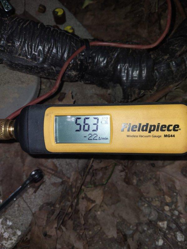 Responded to callback for recently installed AC system blowing warm air and not cooling properly. Upon arrival, performed comprehensive diagnostics using refrigerant manifold gauges and micron gauge to assess system pressures and vacuum levels. Measurements indicated abnormal pressure readings of 2725 and 2724 psig, suggesting potential refrigerant charge issues or system restrictions. Conducted vacuum testing which revealed readings of 563 microns with a decay rate of 2.2 microns per minute, indicating possible leak in the refrigeration circuit. Accessed crawlspace area to inspect indoor unit components and ductwork connections. Identified and documented system conditions with diagnostic equipment readings for warranty documentation and further corrective action recommendations.