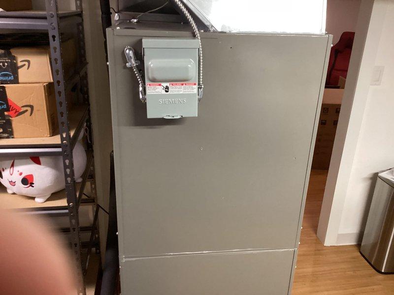 Completed full HVAC system installation including Lennox air conditioning unit, air handler, and T6 programmable thermostat in residential utility area. Air handler was positioned in basement storage area with proper electrical disconnect and conduit installation per code requirements. All components were successfully installed, tested, and left in operational condition.