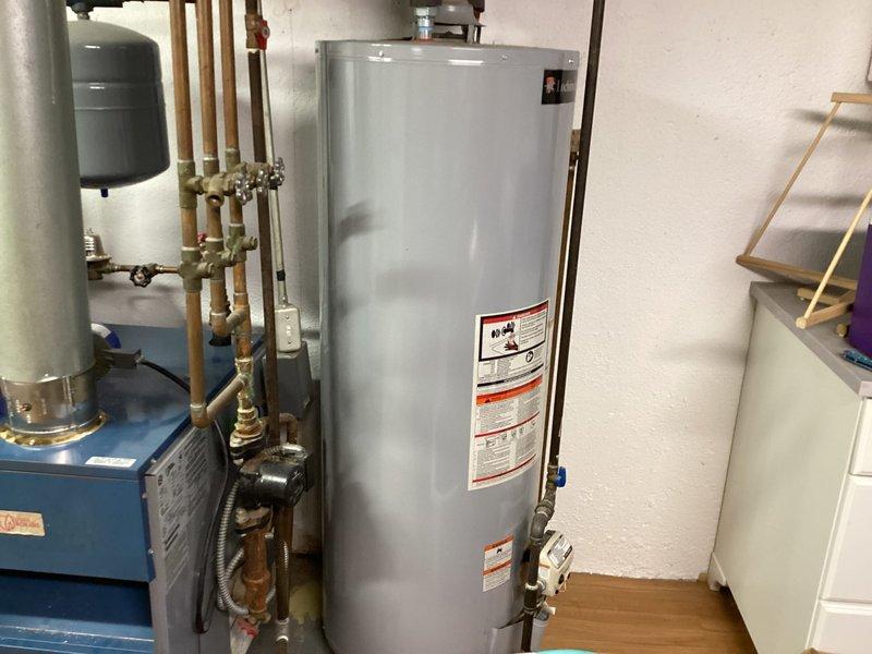 Completed full HVAC system installation including Lennox air conditioning unit, air handler, and T6 programmable thermostat in residential utility area. Air handler was positioned in basement storage area with proper electrical disconnect and conduit installation per code requirements. All components were successfully installed, tested, and left in operational condition.