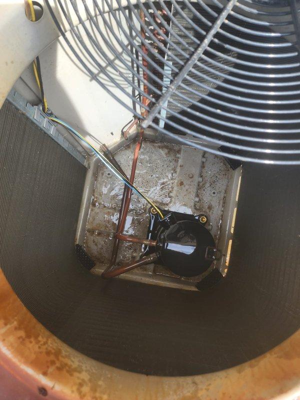 Performed comprehensive cooling season maintenance on outdoor air conditioning unit. Connected diagnostic gauges and measured system pressures and temperatures, with readings indicating 203.7 PSI high side, 86.9 PSI low side, and temperatures of 128.4°F discharge, 44°F suction, with 16.4°F superheat. Inspected condenser coil fins for debris accumulation, verified fan motor operation and fan guard security, and examined electrical components including capacitor and wiring connections. All system parameters found within normal operating range, unit operating efficiently with no deficiencies noted.