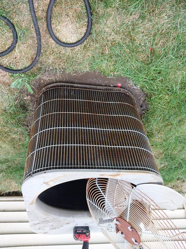 Completed routine AC maintenance on outdoor condensing unit showing significant age and weathering. Performed standard tune-up procedures including inspection of compressor, fan motor, and electrical components; all major components found operational despite visible exterior corrosion on housing and top plate. Cleaned condenser coil fins, checked refrigerant lines, verified proper drainage function, and documented equipment condition with extensive rust present on metal surfaces from prolonged outdoor exposure.