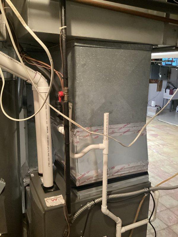 Completed estimate for air conditioning system replacement at residential property. Existing HVAC system was disconnected by another contractor during recent work, revealing advanced age and deterioration of equipment. Assessed current furnace/air handler unit, ductwork, and associated components in basement mechanical room. Documented existing system configuration including copper refrigerant lines, PVC condensate drainage, venting arrangement, and plenum connections. Noted weathered condition of metal ductwork and aging equipment requiring replacement. Photographed installation area and existing system components to provide comprehensive replacement proposal for new HVAC equipment.
