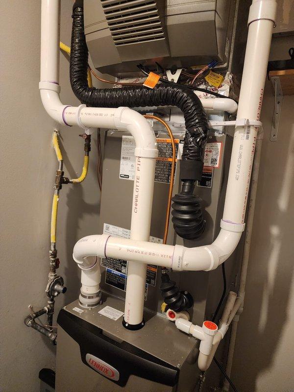 Completed warranty work replacing existing cellular core vent piping with solid core PVC piping on residential HVAC installation per manufacturer specifications. Verified all connections, proper venting configuration, and system operation. Documentation photos captured showing updated white PVC vent piping assembly, gas line connections, condensate components, and complete installation meeting code requirements.