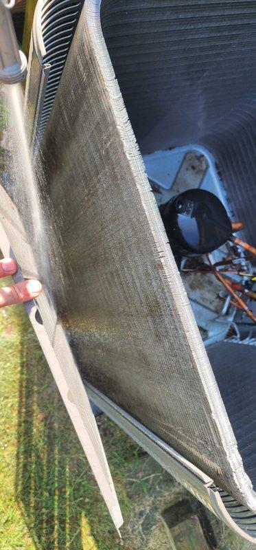 Performed comprehensive annual maintenance on one-year-old outdoor air conditioning unit. Conducted complete system inspection including interior components, electrical connections, and refrigerant lines. Noted condenser coil fins showing accumulation of dirt, dust, and organic debris restricting airflow, particularly in middle and lower sections of fin assembly. Inspected blower motor assembly and associated wiring connections for proper operation. Documented current system condition with photographic evidence showing normal wear patterns for unit age and exterior installation environment. System operational upon completion of tune-up service.