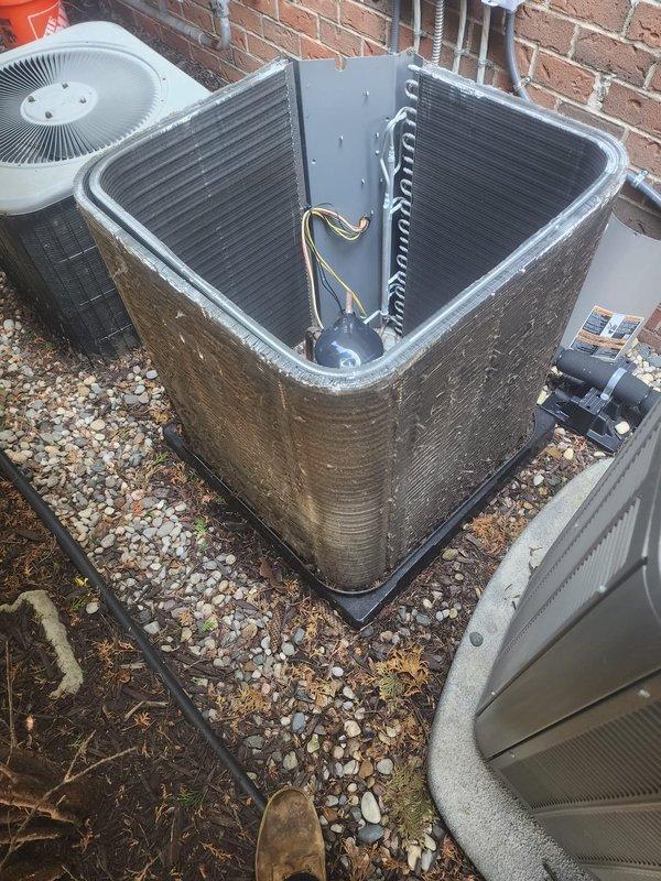 Responded to callback for thermostat temperature control issue where unit would not lower temperature from 1-5 degrees. Upon arrival, inspected outdoor condenser unit and found heavy dirt and grime accumulation on exterior surfaces and fins, along with significant rust and corrosion on compressor mounting plate. Documented equipment condition showing environmental deterioration and debris buildup that could impact system performance and airflow efficiency. Verified refrigerant line connections and compressor operation during inspection.