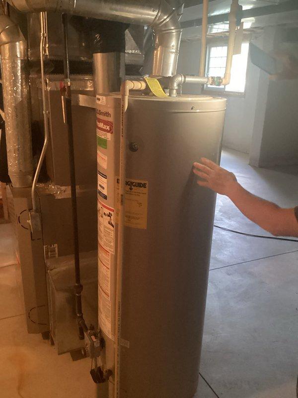 Conducted on-site assessment of existing A.O. Smith ProMax water heater located in basement utility area for replacement estimate. Documented current unit configuration including copper supply line connections, top-mounted valves and fittings, expansion tank setup, and surrounding HVAC equipment proximity. Photographed existing installation to provide accurate replacement specifications and identify any necessary modifications to plumbing connections or venting requirements for new water heater installation.
