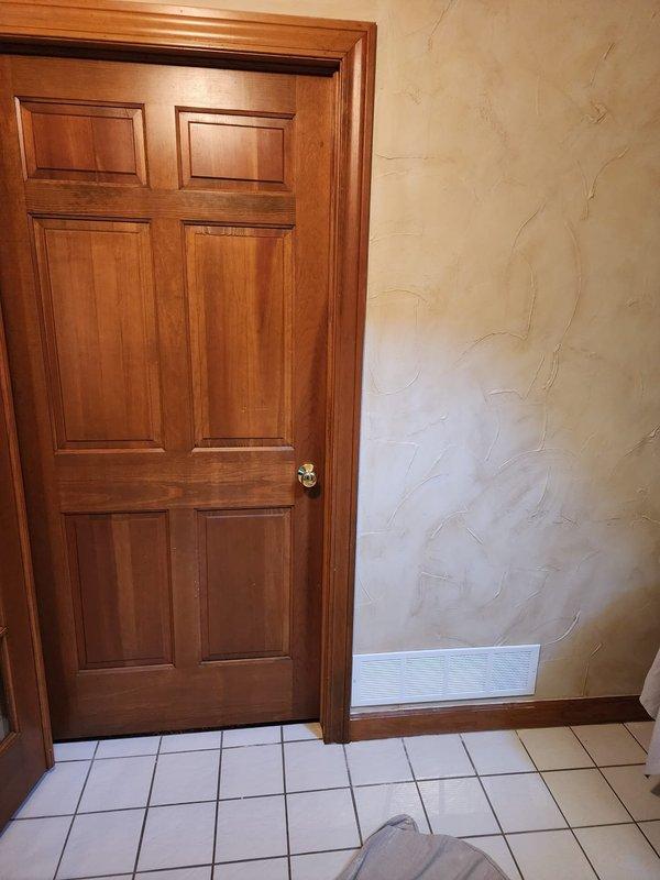 Installed combustion air ventilation system to meet code requirements for tankless water heater operation. Added ventilation grate at wall base to provide adequate air supply of 50 cubic feet per 1,000 BTU as specified by manufacturer and local building codes, ensuring proper combustion and safe operation of the unit.