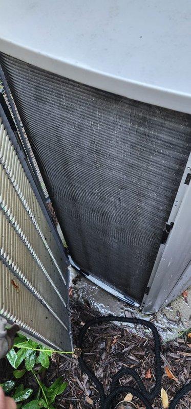 Completed comprehensive cooling season maintenance on residential air conditioning system under Worry Free Service Agreement. Performed standard AC tune-up procedures including inspection of outdoor condenser unit, which revealed moderate debris accumulation of leaves, twigs, and organic matter around base and lower panels requiring removal. Cleaned exterior coil fins and removed vegetation growth from unit perimeter to restore proper airflow. Inspected interior components including evaporator coil section, refrigerant lines, and condensate drain pan. Found standing water and moisture accumulation in drain pan with visible dirt and debris buildup. Cleared condensate drainage system and cleaned drain pan to prevent potential clogs and microbial growth. Verified copper refrigerant lines showed normal patina with no visible leaks or damage. Checked all electrical connections, capacitor operation, and compressor performance. System operating within normal parameters upon completion of main